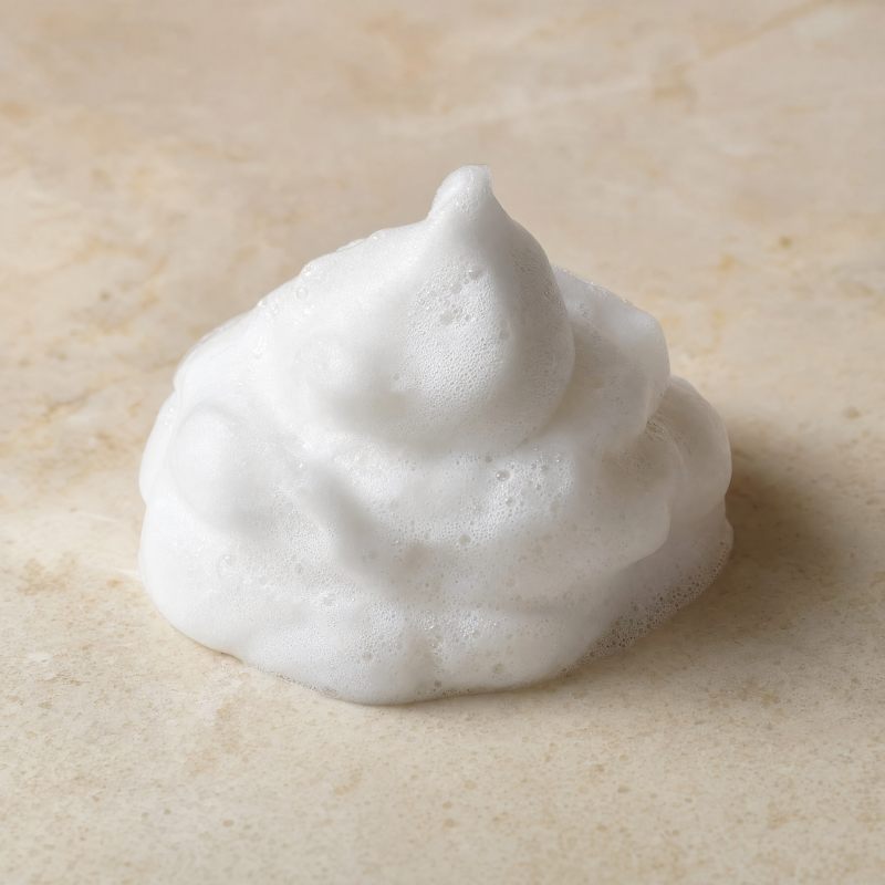 A mound of thick white lather on a stone surface
