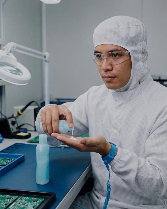 Cleanroom technician in a gown at a bench